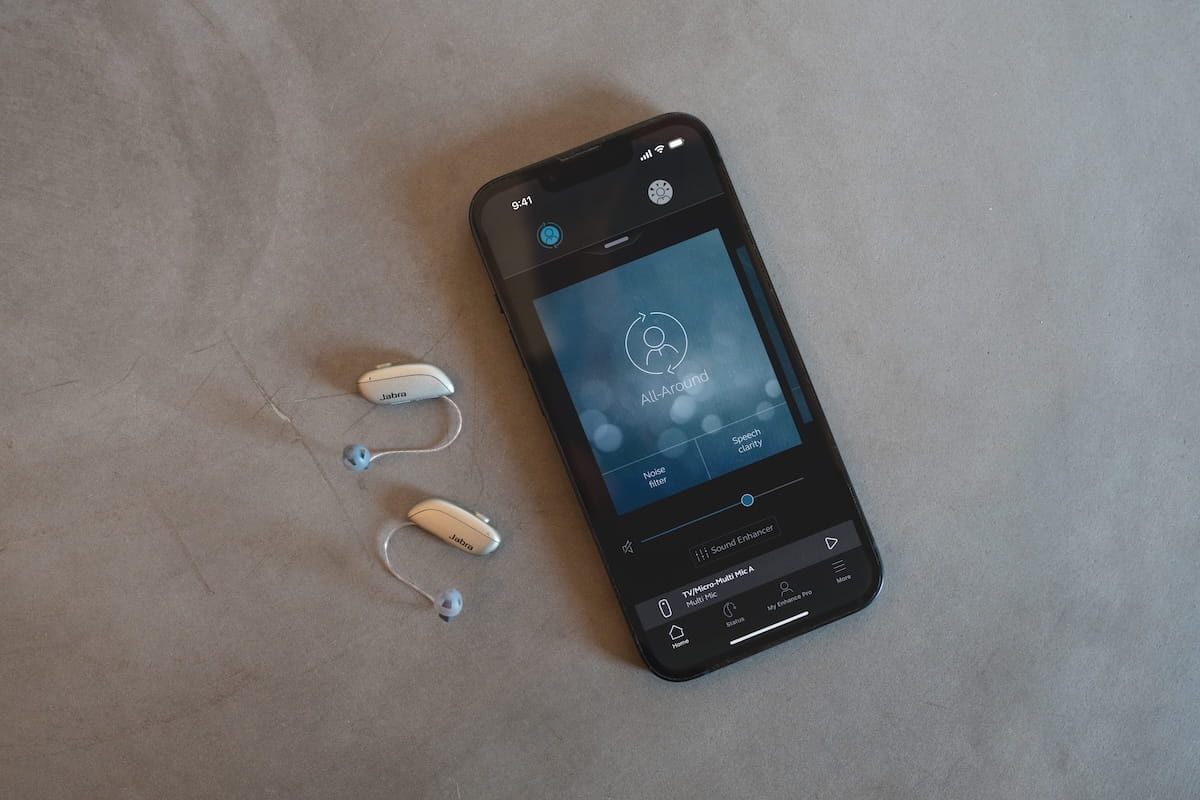 Enhance Pro hearing aid and a smartphone with Jabra Enhance Pro App